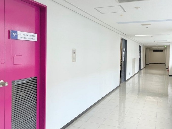 ビル共用廊下　ピンクの扉が目印です